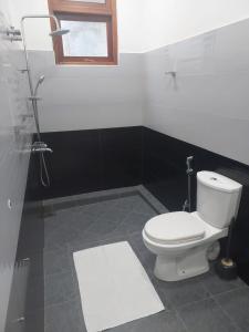 uma casa de banho com um WC branco e uma janela em Ella Zenith View em Ella