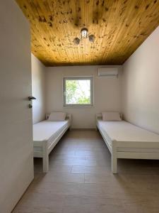 2 camas en una habitación con techo de madera en Villa Ajsa with private heated pool en Gladno Polje