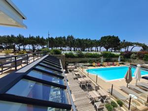 a resort with a swimming pool and chairs at Le Churchill Hôtel & Spa in Carnac