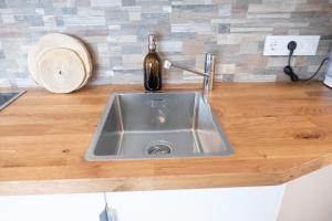 a kitchen counter with a sink and a bottle of wine at Apartment Graf in Bad Aibling