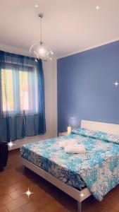 ein Schlafzimmer mit einem Bett und einer blauen Wand in der Unterkunft palinuro centro 2 in Palinuro