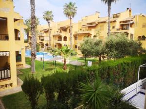 kompleks apartamentów z basenem i palmami w obiekcie NEW Alexandra apartment, 2 min 40 sec from beach w mieście La Mata