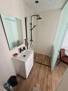 łazienka z umywalką i prysznicem oraz lustrem w obiekcie NEW Alexandra apartment, 2 min 40 sec from beach w mieście La Mata