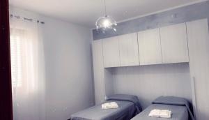 ein kleines Zimmer mit 2 Betten und einem Fenster in der Unterkunft palinuro centro 2 in Palinuro