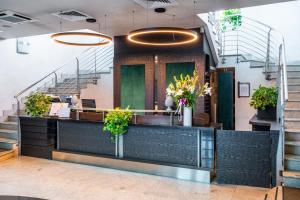 a lobby with a counter with flowers and plants at Hotel Parisi in Nichelino