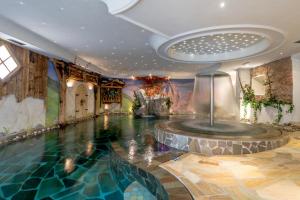 a swimming pool in a room with a water fountain at Park Hotel Sport in Andalo