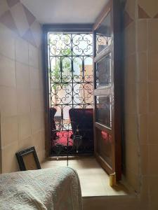 Habitación con ventana y puerta con puerta. en RIAD ALGHANI, en Marrakech