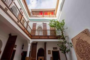 un edificio con balcón y una planta frente a él en RIAD ALGHANI, en Marrakech