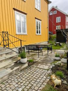 a yellow house with a bench in front of it at Tomannsbolig på Rosenborg in Trondheim