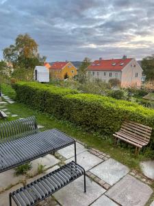 two benches sitting on a patio with buildings in the background at Tomannsbolig på Rosenborg in Trondheim