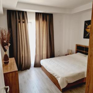 a bedroom with a bed and a large window at Comfort cosmopolis in Ştefăneştii de Jos