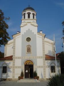 a white church with a tower with a clock at Къща за гости Бор in Pomorie