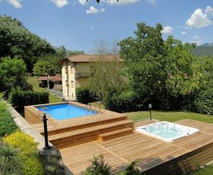 a backyard with a pool and a wooden deck with a swimming pool at Agriturismo La Locanda del Cardinale in Poggio