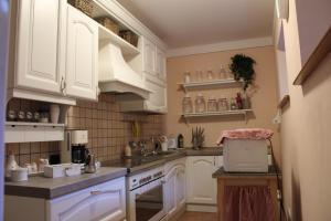 a kitchen with white cabinets and a laptop on the counter at Agriturismo La Locanda del Cardinale in Poggio