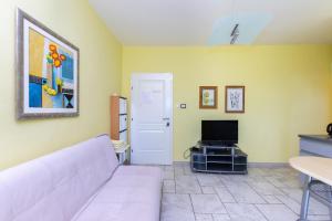 a living room with a white couch and a tv at Apartments Rada i Stanislav in Barbat na Rabu