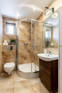 a bathroom with a shower and a toilet and a sink at SopotSpanie in Sopot +58 photos