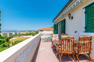 a balcony with two chairs and a wooden table at Apartments Rada i Stanislav in Barbat na Rabu