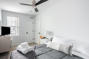 a white bedroom with a bed and a ceiling fan at Modern Fishtown Townhouse in Philadelphia