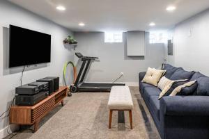 a living room with a blue couch and a treadmill at Modern Fishtown Townhouse in Philadelphia