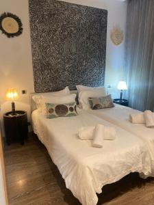 1 dormitorio con 1 cama blanca y 2 toallas en Résidence Le Vizir Center Rez de jardin, en Marrakech