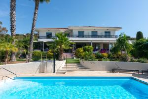 a house with a swimming pool in front of a house at HOTEL LA QUIETUDE in Les Issambres