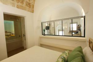 1 dormitorio con espejo grande en la pared en Casa Mamaroca 63, en Ostuni