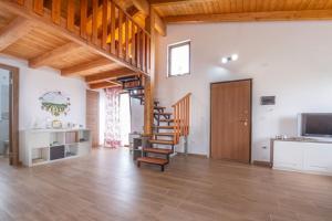 una gran sala de estar con techos de madera y una escalera. en [La casa nel vigneto] - San Vito Chietino, en Marina di San Vito