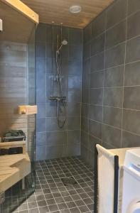 a bathroom with a shower with gray tiles at Polar Charm A in Ylläs