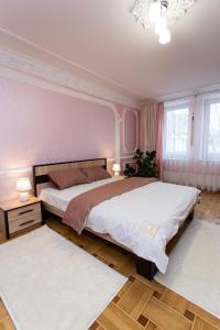 a bedroom with a large bed and two rugs at Центр. Вулиця Липова. 3 кімнати in Ternopilʼ