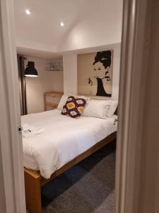 a bedroom with a bed with a picture of a woman at Top floor Warren st flat. in London