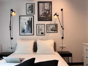 a bedroom with a bed with four pictures on the wall at apartamenty-wroc Księcia Witolda by the River in Wrocław +58 photos