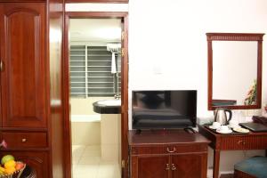 a living room with a television and a bathroom with a tub at Hotel West Valley - Baridhara in Dhaka