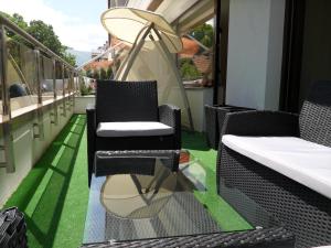 d'un balcon avec des chaises, une table et de la pelouse. dans l'établissement Apartments Las Tres Palmas, à Sofia