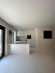a white kitchen with a white counter in a room at Chez Victorine Kortrijk in Kortrijk