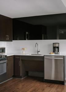 a kitchen with black cabinets and a sink at Sonder at Commerce in Dallas