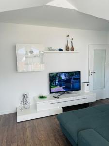 a living room with a flat screen tv on a white cabinet at Ferienwohnung Moments klimatisiert in Balingen