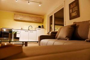 a living room with a couch and a kitchen at Ferienwohnung über den Dächern von Oberelsbach in Oberelsbach