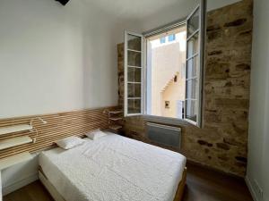 um quarto com uma cama e uma janela em Le Multipliant em Montpellier