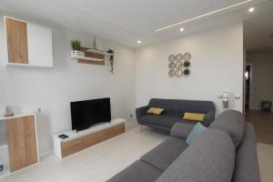 ein Wohnzimmer mit einem Sofa und einem Flachbild-TV in der Unterkunft Praia_da_Rocha_Vista_Mar/Ocean_View in Portimão