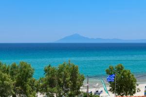 een uitzicht op een strand met bomen en de oceaan bij Boutique Giannikis By The Beach in Limenaria