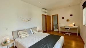 a bedroom with a large bed and a desk at Balaia Prestige by Check-in Portugal in Albufeira