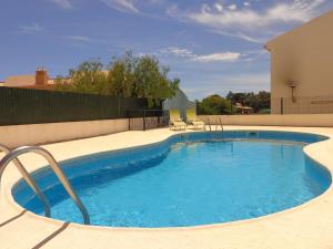 een groot zwembad met blauw water in een tuin bij Balaia Prestige by Check-in Portugal in Albufeira