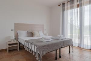 ein weißes Schlafzimmer mit einem Bett mit Handtüchern darauf in der Unterkunft Villa Mura - YourPlace Abruzzo in Fossacesia