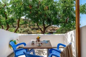 a table and chairs on a balcony with a tree at Seaview Mastrozanne Studio 8 Andros in Andros