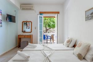 a room with two beds and a mirror and a table at Seaview Mastrozanne Studio 8 Andros in Andros