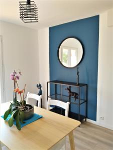 uma sala de jantar com paredes azuis e uma mesa com um espelho em Superbe bas de villa 80 m2 très calme et frais avec vue magnifique 6 couchages em La Londe-les-Maures