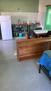 Habitación con cama de madera y nevera. en La Casita, en Los Reartes