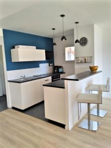 uma cozinha com armários brancos e um balcão preto em Superbe bas de villa 80 m2 très calme et frais avec vue magnifique 6 couchages em La Londe-les-Maures