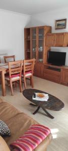 a living room with a table and a tv at Piso As Rodas in Villanueva de Arosa