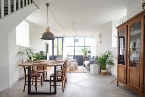 a dining room and living room with a table and chairs at Gîte avec tennis en Baie du Mont Saint Michel à 15 minutes de la mer in Les Chambres